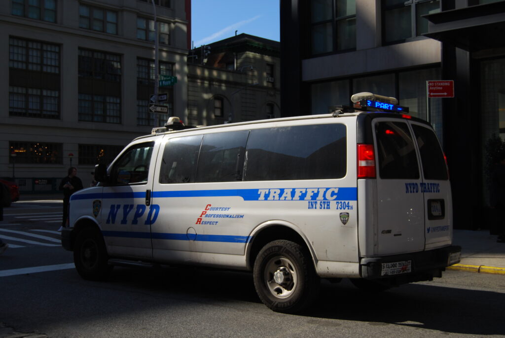 Camionnette du service de policede New York sur un coins de rue en ville.