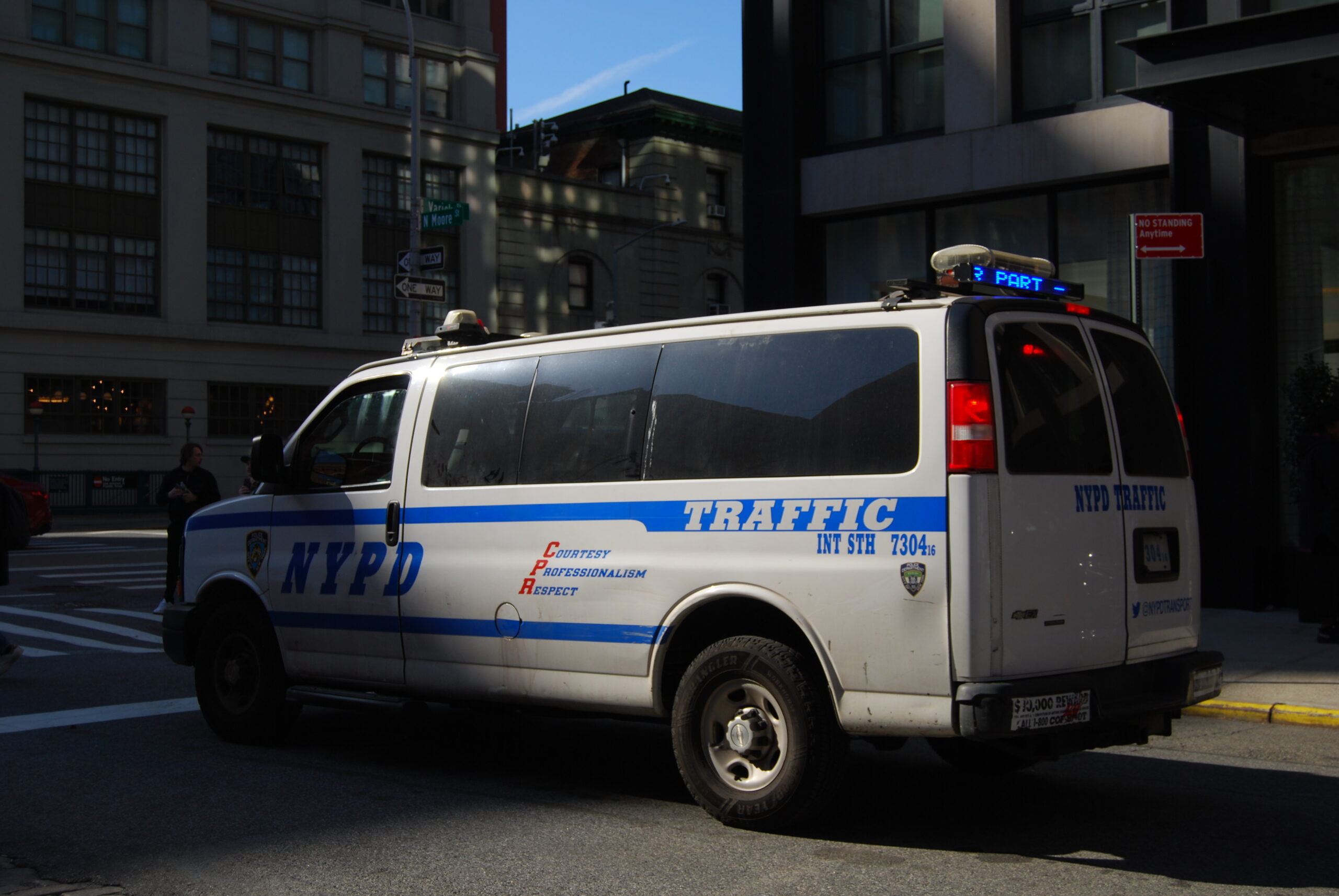 Camionnette du service de policede New York sur un coins de rue en ville.