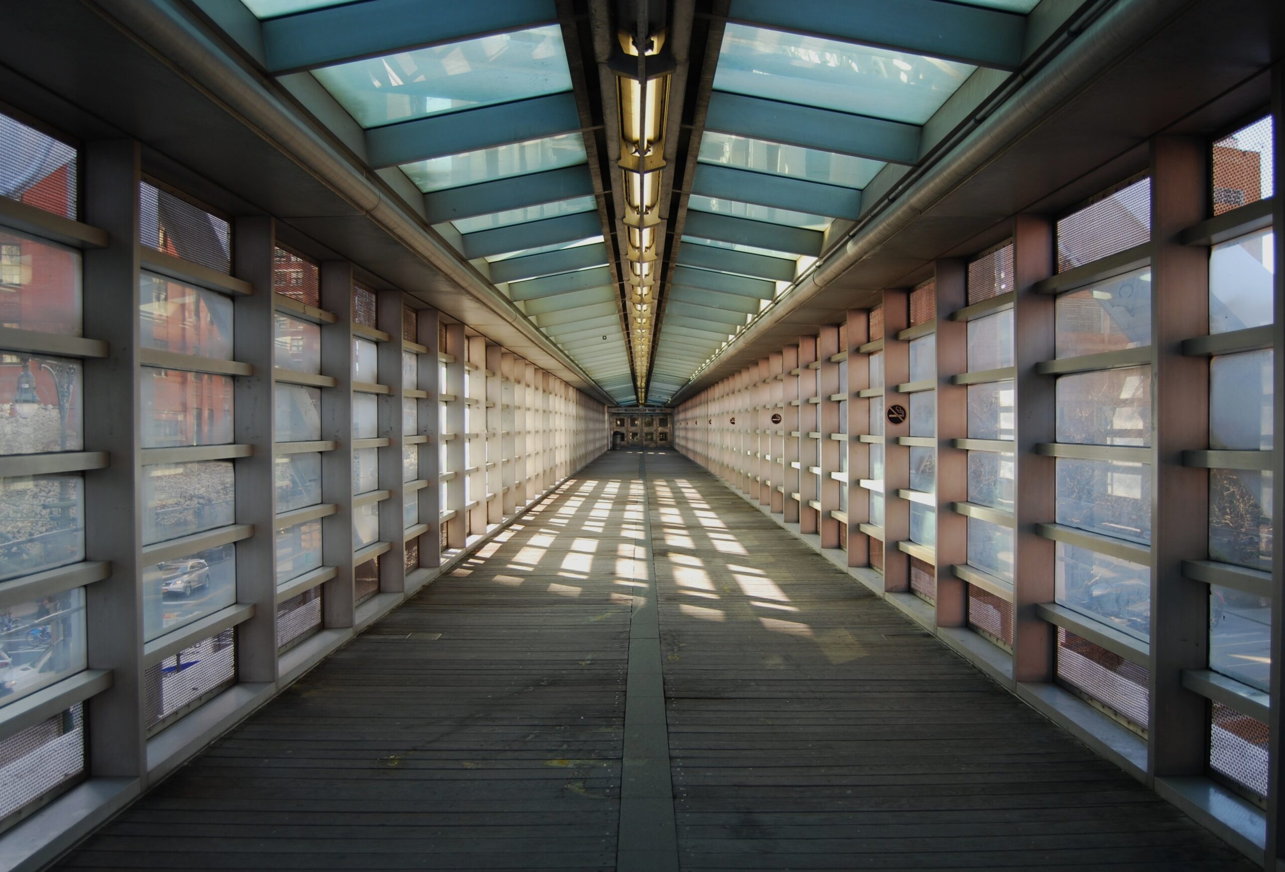Passage couvert / tunnel vitré lumineux vu du centre.